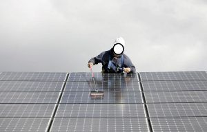 Persona limpiando placas solares